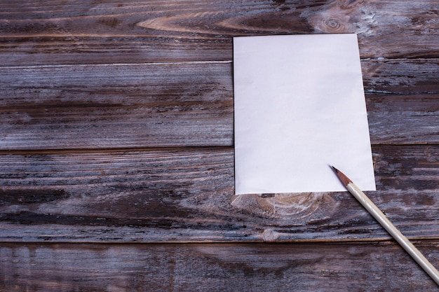 Foto papel em branco e lápis na mesa de madeira