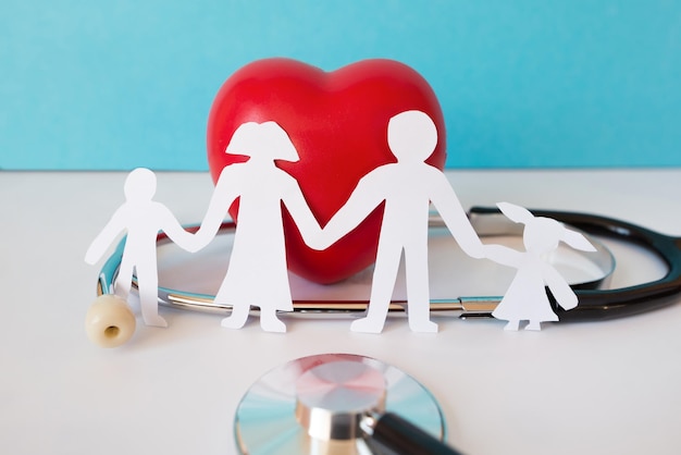 Papel de familia cortado con corazón rojo y estetoscopio salud cardíaca concepto de seguro de salud familiar Cruz Roja RCP