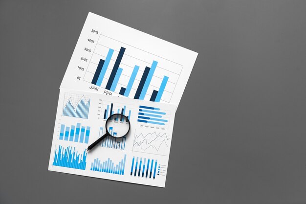 Papel financeiro com gráficos e diagramas na mesa cinza