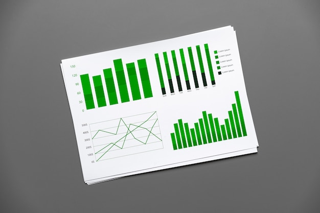 Papel financiero con gráficos y diagramas en mesa gris