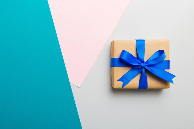 Papel hecho a mano de vacaciones presente atado cinta azul arco vista superior con espacio de copia Fondo plano de vacaciones Cumpleaños o regalo de Navidad Concepto de caja de regalo de Navidad con espacio de copia