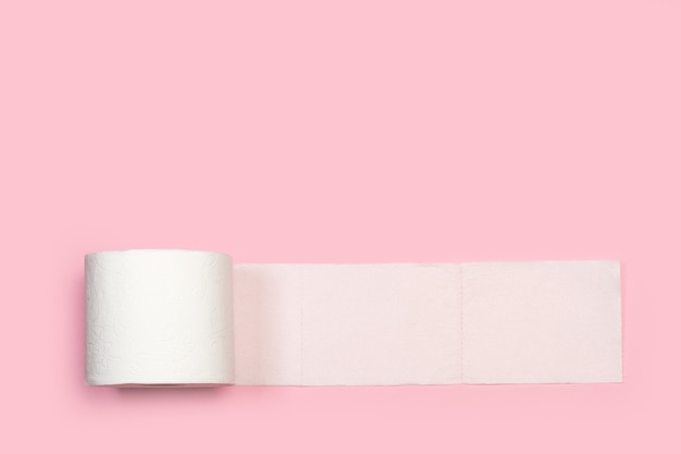 Papel higiénico sobre un fondo rosa en una vista superior