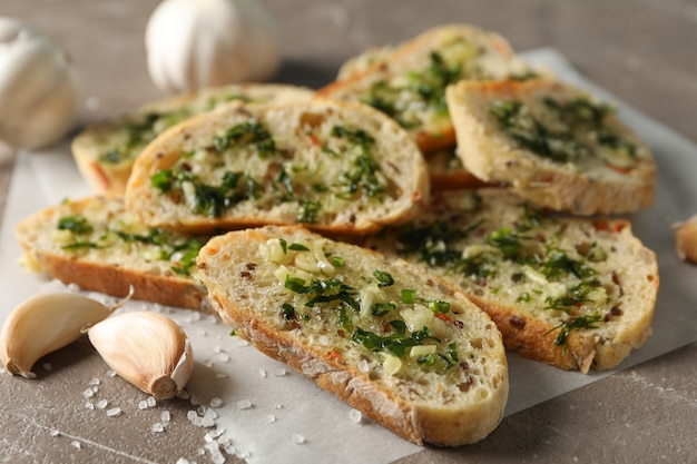 Papel para hornear con pan de ajo tostado en gris, de cerca