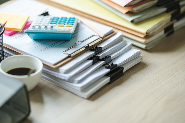 Papel de informe financiero y máquina de cálculo en el escritorio de oficina de mesa, conceptos de finanzas y contabilidad