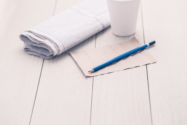 Papel y lápiz en la mesa de madera.