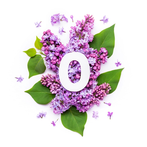 Papel número cero sobre fondo de flores lilas. Diseño creativo mínimo con elementos naturales para su diseño.