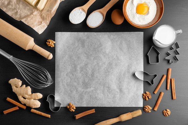 Papel pergamino e ingredientes para masa en la mesa de la cocina