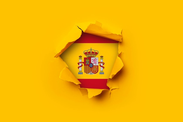 Papel rasgado amarillo dentro de un agujero Bandera de España. Fondo de bandera, papel tapiz.