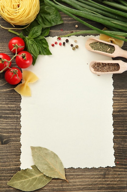 Foto papel para recetas verduras y especias en mesa de madera.