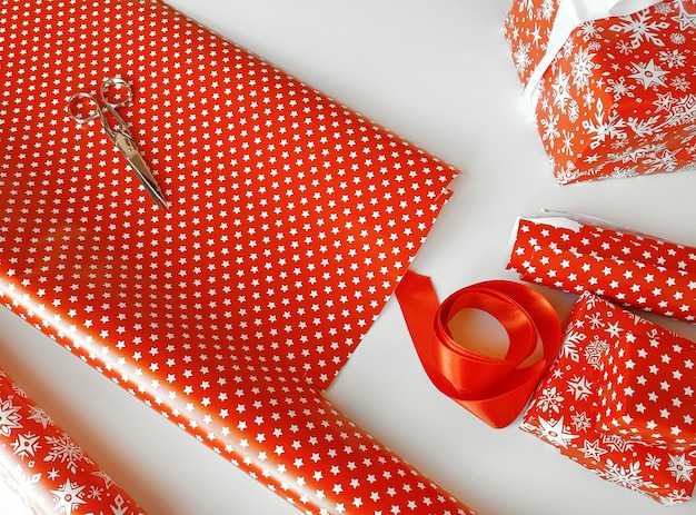 Papel de regalo rojo para regalos en una mesa blanca