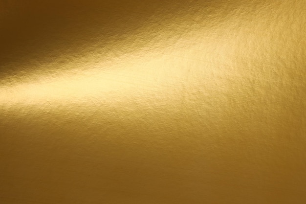 Un papel tapiz dorado que es dorado con una luz brillando sobre él.