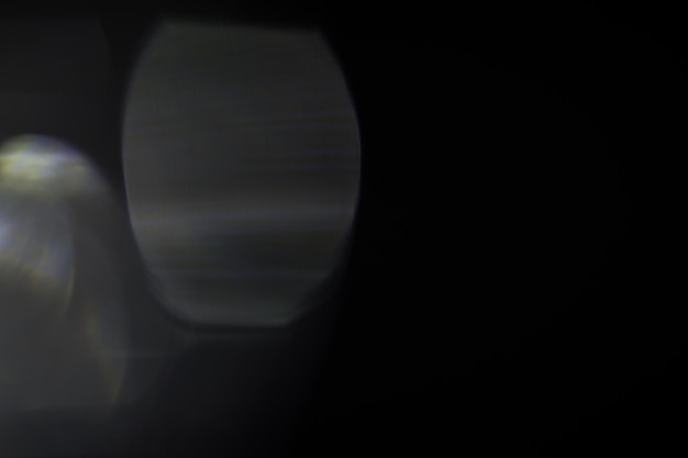 Papel tapiz oscuro con fugas de luz bokeh contra un fondo negro para superposiciones