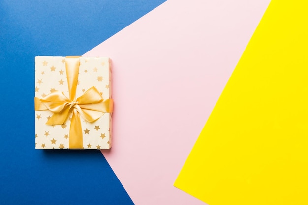 Papel de vacaciones presente atado cinta amarilla arco vista superior con espacio de copia Fondo plano de vacaciones Cumpleaños o regalo de Navidad Concepto de caja de regalo de Navidad con espacio de copia
