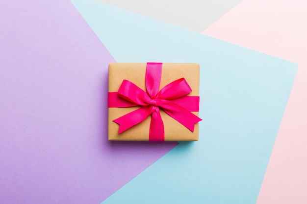 Papel de vacaciones presente atado cinta rosa lazo vista superior con espacio de copia Fondo plano de vacaciones Cumpleaños o regalo de Navidad Concepto de caja de regalo de Navidad con espacio de copia