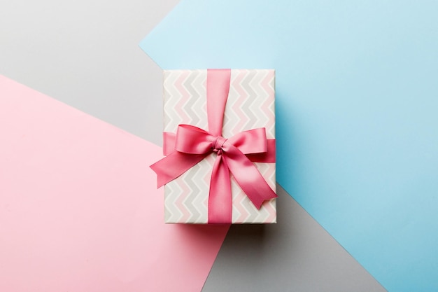 Papel de vacaciones presente atado cinta rosa lazo vista superior con espacio de copia Fondo plano de vacaciones Cumpleaños o regalo de Navidad Concepto de caja de regalo de Navidad con espacio de copia