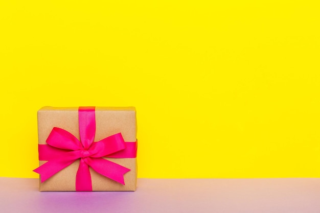 Papel de vacaciones presente atado cinta rosa lazo vista superior con espacio de copia Fondo plano de vacaciones Cumpleaños o regalo de Navidad Concepto de caja de regalo de Navidad con espacio de copia