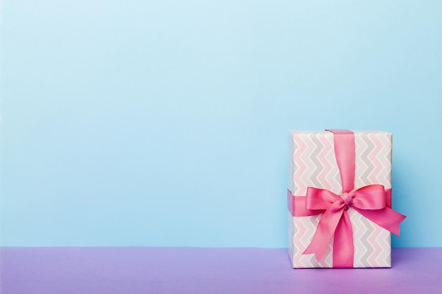 Papel de vacaciones presente atado cinta rosa lazo vista superior con espacio de copia Fondo plano de vacaciones Cumpleaños o regalo de Navidad Concepto de caja de regalo de Navidad con espacio de copia