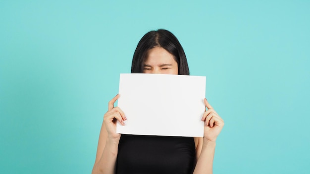 Papel vacío en blanco en la mano de la mujer asiática sobre fondo verde menta o azul Tiffany