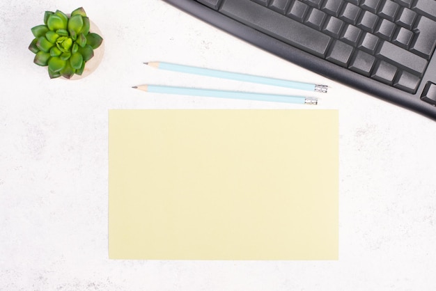 Papel vacío con un bolígrafo, teclado de computadora y un cactus, fondo texturizado, lluvia de ideas