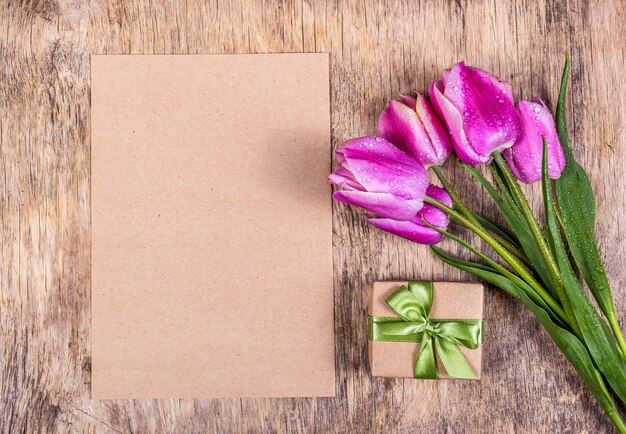 Papel vacío con caja de regalo y tulipanes