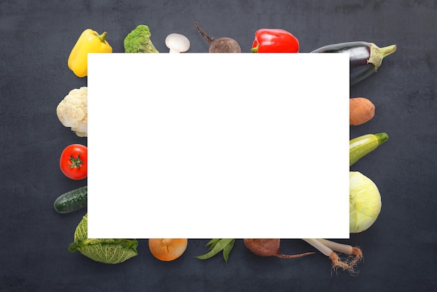 Papel vacío sobre verduras sobre un fondo oscuro Concepto Vista superior