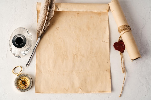 Papel velho com vista superior de bússola e caneta de pena