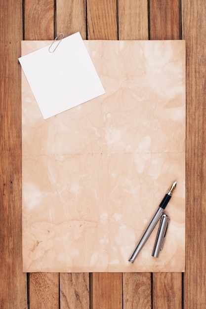 Foto papel viejo en un escritorio de madera con pluma estilográfica