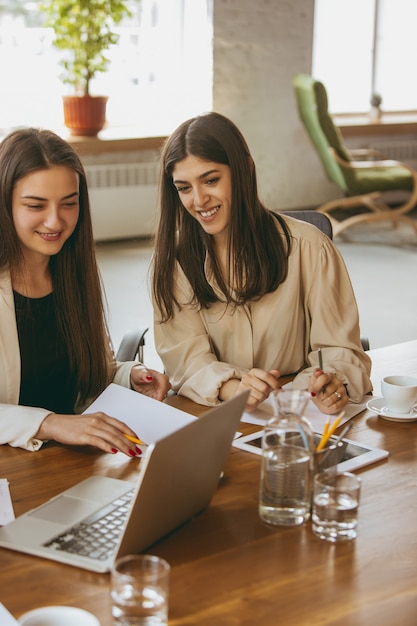 Papelada. Mulher de negócios jovem em um escritório moderno com a equipe. Reunião criativa, atribuição de tarefas. Mulheres trabalhando no escritório. Conceito de finanças, negócios, poder feminino, inclusão, diversidade, feminismo.