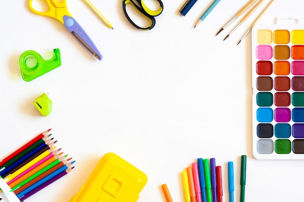 Papelaria para a escola e trabalho criativo em um fundo branco, lay-out plana, vista de cima, espaço de cópia