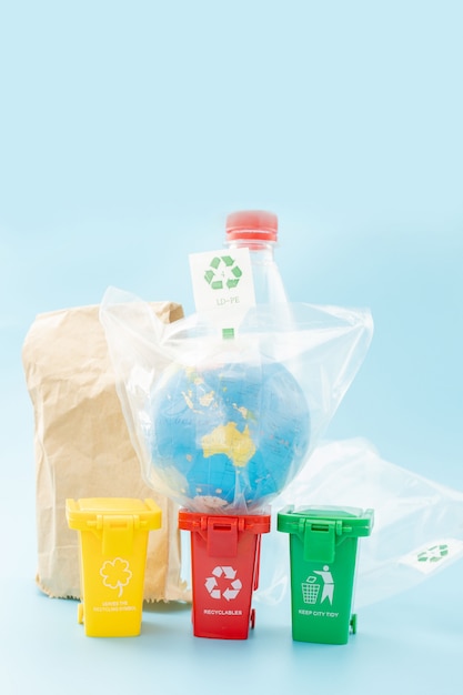 Papeleras de reciclaje amarillas, verdes y rojas con el símbolo de reciclaje sobre fondo azul. Mantenga la ciudad ordenada, deja el símbolo de reciclaje. Concepto de protección de la naturaleza