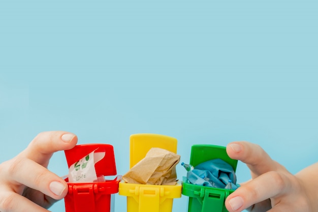 Papeleras de reciclaje amarillas, verdes y rojas con el símbolo de reciclaje en la superficie azul. Mantenga la ciudad ordenada, deja el símbolo de reciclaje. Concepto de protección de la naturaleza