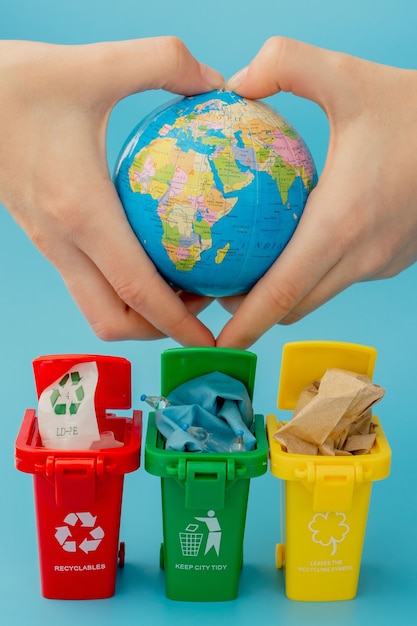 Papeleras de reciclaje amarillas, verdes y rojas con símbolo de reciclaje