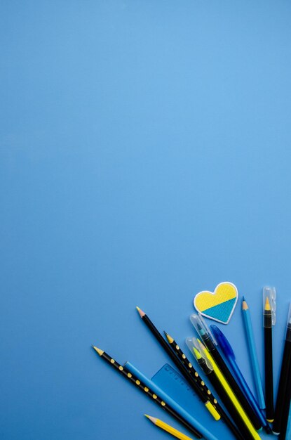Papelería y corazón con los colores de la bandera ucraniana en un fondo azul