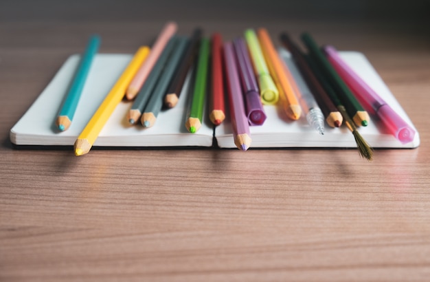 Papelería y cuaderno coloridos sobre fondo de madera. volver al concepto de escuela