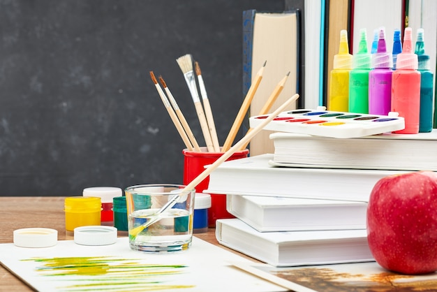 Papelería para la escuela en un carro en el fondo de una pizarra