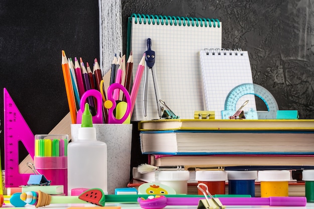 Papelería en una mesa delante de la pizarra