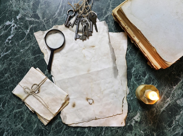 Papeles retro y libro sobre la mesa de trabajo de detective con fondo de herramientas