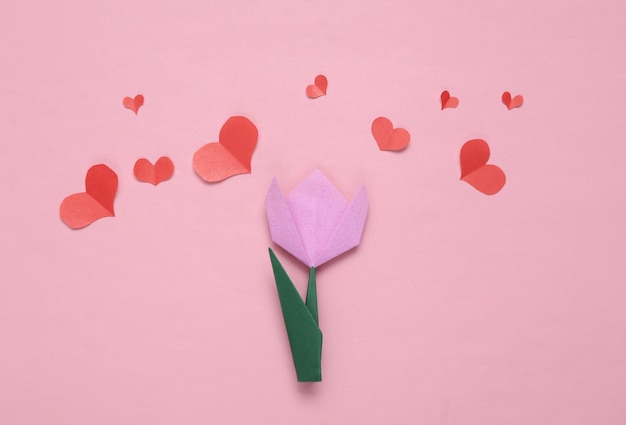 Papier geschnitten Rote Herzen und Origami-Tulpe auf rosa Hintergrund Valentinstag-Konzept Ansicht von oben