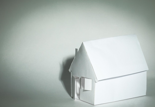 Papierhaus Papierhintergrunddas Konzept einer Hypothek