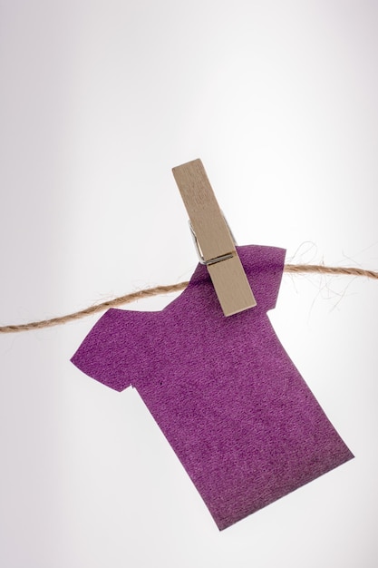 Papierkleider hängen mit Wäscheklammern an einem Seil