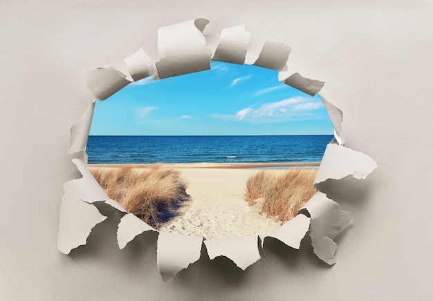 Papierloch mit Bild des einsamen Strandes an der Ostsee mit Gras auf Dünen und Meer. Last-Minute-Angebot, Rabatt. Wiedereröffnung von Northerner Europe, Urlaub nach Quarantäne.