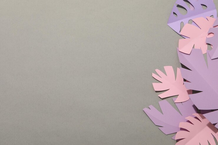 Papierrosa und lila tropische Blätter auf grauem Hintergrund