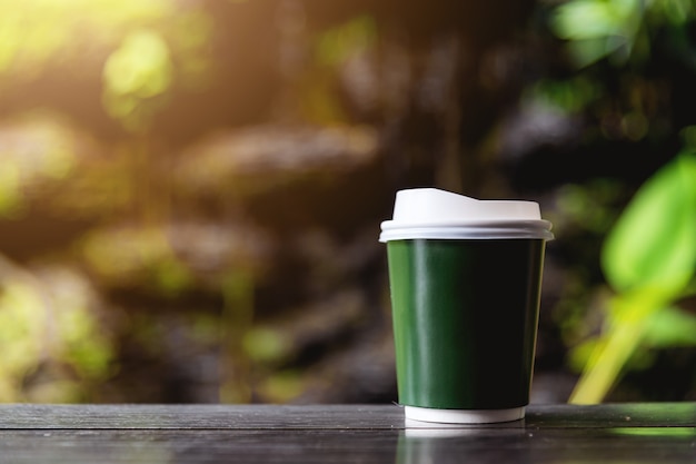 Papierschale heißer Kaffee auf hölzerner Tabelle