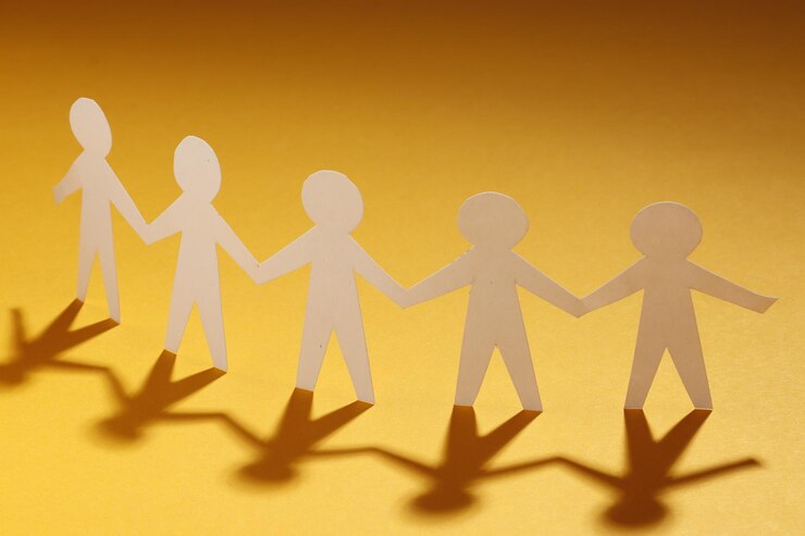 Papierschnitt-Stilkonzept eines Führers und der Beziehung zu Freundschaft und Händchenhalten von Menschen in symbolischer Form auf Inspirationsstil und modernem orangefarbenem Pastenhintergrund - 3D-Rendering