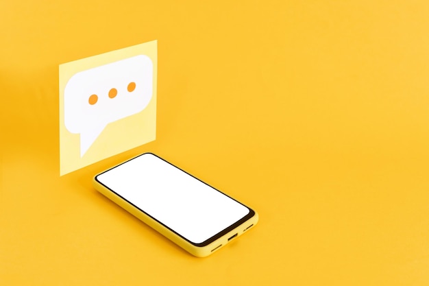 Papiersprechblasen und Smartphone mit leerem Bildschirm auf gelbem Hintergrund Isometrische Ansicht