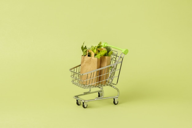 Papiertüten mit frischem grünem Salat im Wagen