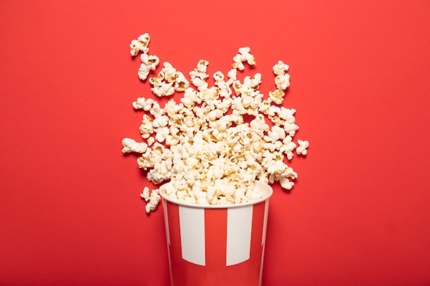 Pappbecher mit Popcorn auf einem roten Hintergrund