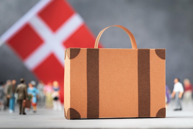 Pappkoffer, Plastikspielzeug, Menschen und Flaggenkonzept zum Thema Umzug oder Migration in Schweden