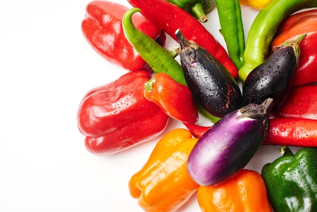 Paprika, Kirschtomaten, Auberginen und Dill auf weißem Hintergrund mit Kopierbereich. Frisches mehrfarbiges Gemüse.