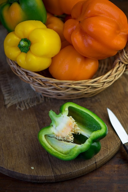 Paprika rot grün gelber Pfeffer auf Holzbrett volle Schärfentiefe